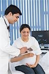 Männlichen Arzt mit Ultraschall auf schwangere Frau