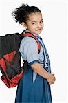 Portrait of a schoolgirl carrying a schoolbag and smiling