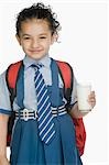 Porträt einer Schülerin hält ein Glas Milch und Lächeln