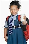 Porträt einer Schülerin hält ein Glas Milch und Lächeln