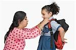 Woman preparing her daughter for school