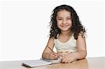 Portrait d'une jeune fille écrivant et souriant