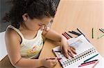 Close-up of a girl drawing a picture with crayons