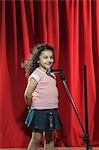 Jeune fille jouant avec un microphone sur une scène