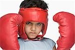 Portrait of a boy wearing boxing gloves and head protector