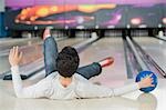 Young man falling in a bowling alley