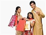 Couple and their daughter carrying shopping bags and credit card