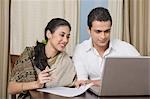 Couple preparing home budget on a laptop