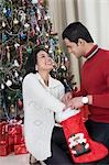 Couple holding a Christmas stocking and smiling