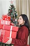 Woman holding Christmas presents and smiling