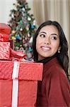 Woman holding Christmas presents and smiling