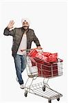 Man pushing a shopping cart of gifts