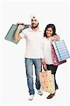 Couple carrying shopping bags and smiling