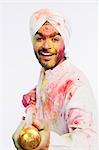 Portrait of a man playing Holi with a pichkari