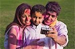 Family taking picture of themselves with a digital camera on Holi