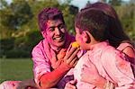 Family celebrating Holi with traditional Indian cuisines