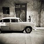 Image taken with a Holga medium format 120 film toy camera of man walking past old American car, Havana, Cuba, West Indies, Central America