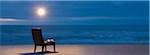 Ampoule éclairée la nuit sur une chaise sur la plage