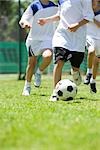 Children playing soccer, cropped