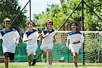 Boys running on soccer field