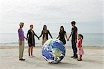 Ecology concept, group of people holding hands, standing around the planet earth