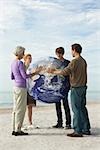 Ecology concept, four people placing hands on earth together