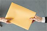 Handing colleague large brown envelope