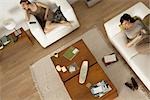 Women relaxing in living room, one listening to MP3 player