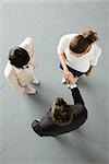 Business people shaking hands, overhead view