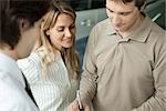 Woman watching as husband signs document