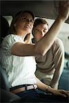 Couple checking out new car interior in dealership showroom