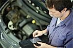 Mechanic using electronic tools to evaluate car performance