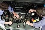 Mechanics reparing car engine