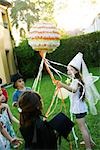 Children pulling streamers attached to pull string pinata