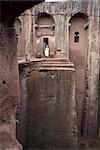 Un prêtre est à l'entrée beta pour le rupestres église de Gabriel-Raphael, à Lalibela, patrimoine mondial UNESCO, Ethiopie, Afrique