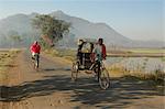 Early morning rickshaw wallahs pass each other in rural countryside near Baliguda, Orissa, India, Asia