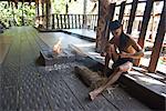 Orang Ulu tribesman whittling wood in traditional Orang Ulu longhouse, Sarawak Cultural Village, Kuching, Sarawak, Malaysian Borneo, Malaysia, Southeast Asia, Asia