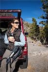 Femme buvant café sur le hayon arrière du véhicule, Donner Summit, près de Lake Tahoe, Californie, USA