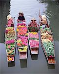 Eine Gruppe von vier Frauen Markt Händler in Booten beladen mit Obst und Blumen, schwimmende Markt von Damnoen Saduak, Bangkok, Thailand, Südostasien, Asien