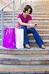 Femme à l'aide de téléphone portable lors de Shopping