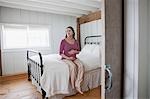 Femme enceinte assise sur le lit