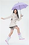 Woman holding umbrella and jumping