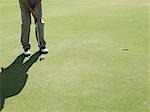 Man playing golf, on putting green