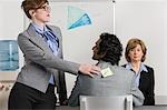 Businesswoman sticking adhesive note to man's back