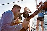 Friends dancing with guitar on yacht