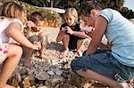 Kinder hören Muscheln am Strand