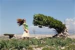 Femme avec les cheveux emportées par le vent et les arbres
