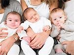 Three babies in mothers arms