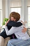 Mother and daughter hugging on couch