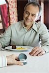 Mature man giving woman diamond ring, cropped